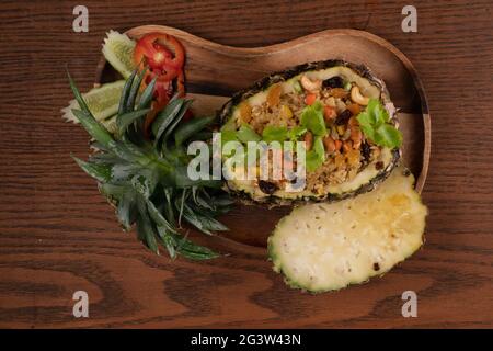 Vista dall'alto cibo tailandese ananas pollo riso fritto su tavolo di legno Foto Stock