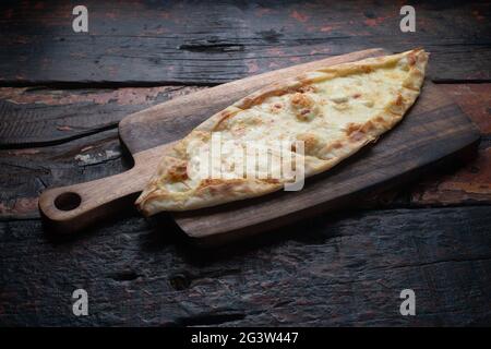 Pide turca con formaggio su tavola rustica in legno Foto Stock