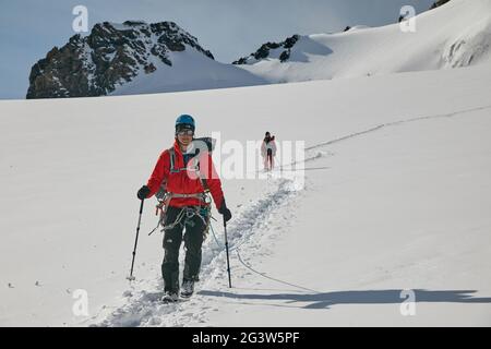 Scalatori che camminano sul ghiacciaio Foto Stock