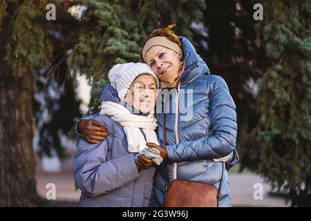 Coppia di donne caucasiche mature e donne senior sono felici di trascorrere il tempo per Natale e Capodanno insieme, sorridendo Foto Stock