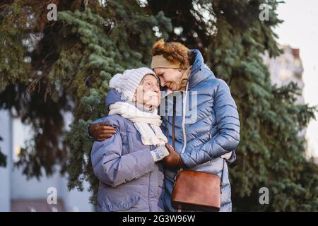 Coppia di donne caucasiche mature e donne senior sono felici di trascorrere il tempo per Natale e Capodanno insieme, sorridendo Foto Stock