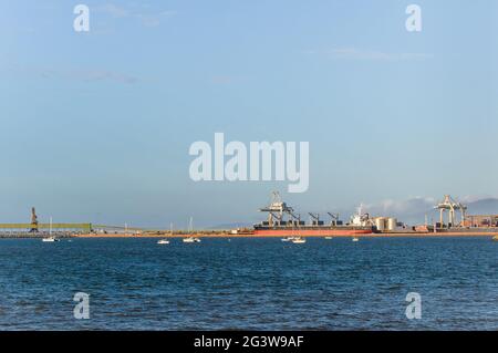 Una vista ordinata sull'orizzonte del porto marittimo di Townsville in Australia con un portarinfuse birthed e caricato in attesa di partenza. Foto Stock