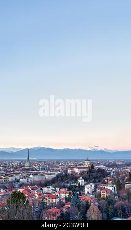 Skyline panoramico di Torino al tramonto con le Alpi sullo sfondo Foto Stock
