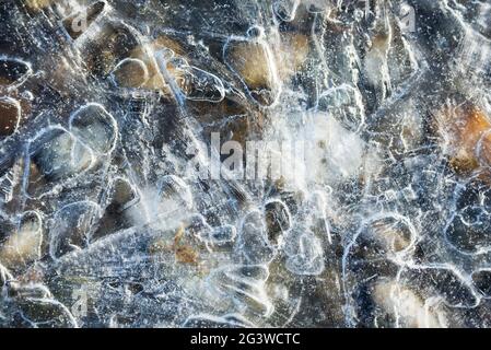 Ciottoli sulla spiaggia coperti di ghiaccio Foto Stock