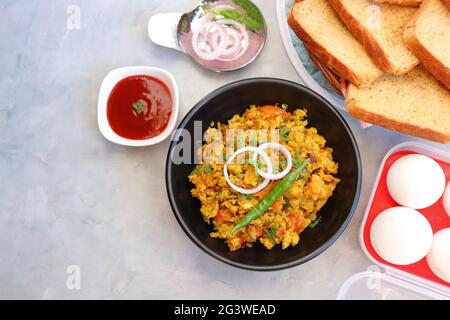 Piatto indiano per la colazione - Parsi Akuri o Anda Bhurji o uova strapazzate speziate indiane servite con pane marrone tostato e ketchup. Famoso cibo di strada indiano Foto Stock