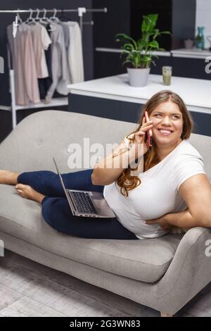 Felice parlare con nutrizionista di come perdere peso grasso ragazza che lavora sul portatile seduto a casa. Autoaccettazione. Lavoro lontano Foto Stock