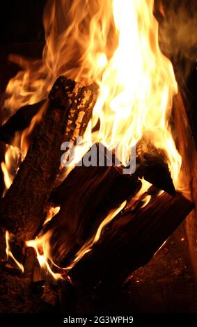 Enormi tronchi di legno brucia forte in Un primo piano scuro Foto Stock