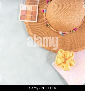 Estate luminoso sfondo in pietra grigio turchese con beauty bag e cappello di paglia Foto Stock