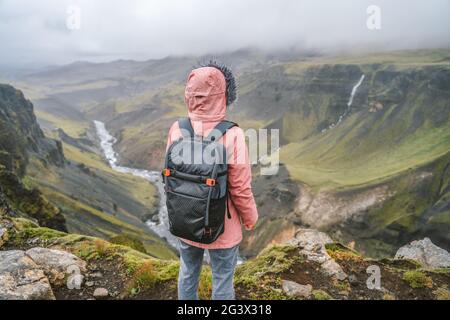Donna escursionista con zaino godendo l'altopiano islandese e fossa fiume vicino alla cascata di Haifoss in Islanda Foto Stock