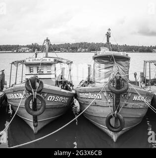 foto in bianco e nero di vecchie imbarcazioni da pesca allineate in un porto di pescatori Foto Stock