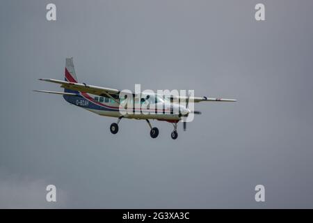 Un aereo leggero Cessna Grand Caravan 208B torna a terra su una pista di erba Foto Stock