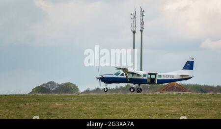 Un aereo leggero Cessna Grand Caravan 208B torna a terra su una pista di erba Foto Stock