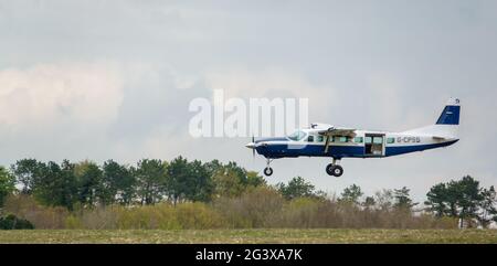 Un aereo leggero Cessna Grand Caravan 208B torna a terra su una pista di erba Foto Stock