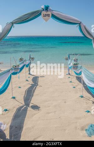 Il setup di giorno di nozze matrimonio corsia con tendaggi e arco sulla sabbiosa spiaggia tropicale paradiso per aprire Sfondo oceano Foto Stock