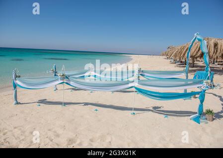 Il setup di giorno di nozze matrimonio corsia con tendaggi e arco sulla sabbiosa spiaggia tropicale paradiso per aprire Sfondo oceano Foto Stock