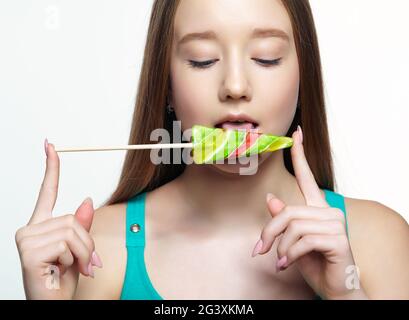 Ragazza adolescente che lecca il lollipop. Concetto di dente dolce Foto Stock