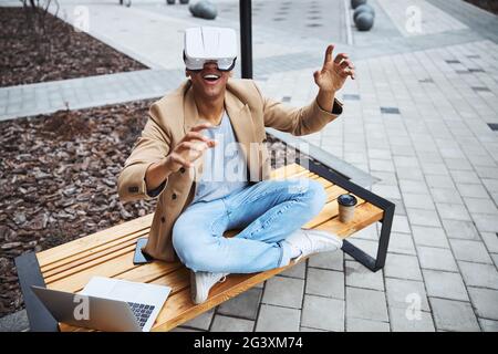 Positivo felice uomo che indossa nuovo gadget Foto Stock