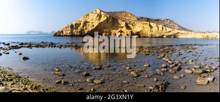 Una vista panoramica di una baia appartata e spiaggia su La costa mediterranea della Spagna con grotte e scogliere di arenaria dietro Foto Stock