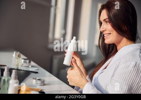 Gioiosa donna bruna seduta in semi posizione Foto Stock