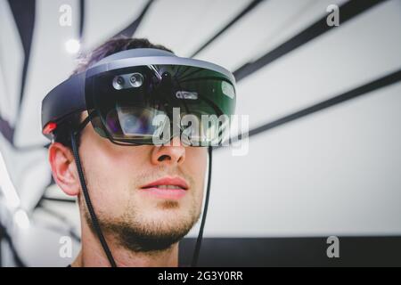 Giovane uomo che indossa occhiali di alta qualità per la realtà virtuale. Concept per la realtà virtuale, il futuro, i gadget e la tecnologia. Foto Stock