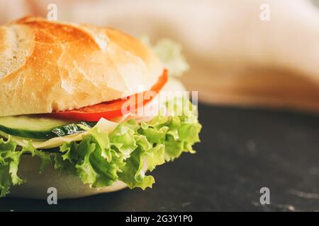 Sandwich con prosciutto, formaggio, verdure e lattuga, fast food Foto Stock