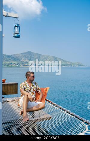 Molo di legno nell'oceano Pattaya Bangsaray spiaggia Thailandia, uomo che cammina sul molo di legno durante le vacanze Thailandia Foto Stock