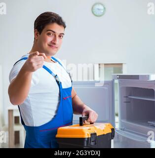 Repairman contraente riparazione frigorifero nel concetto di DIY Foto Stock