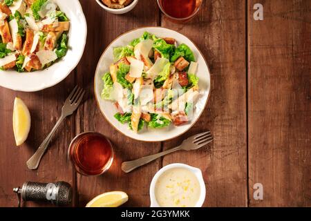 Caesar insalata, top shot su uno sfondo di legno rustico scuro Foto Stock