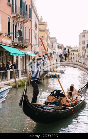 Venezia, Italia - 04 ottobre 2019: Matrimonio in Italia a Venezia. Un gondoliere rotola una sposa e uno sposo in una classica gondola di legno lungo Foto Stock