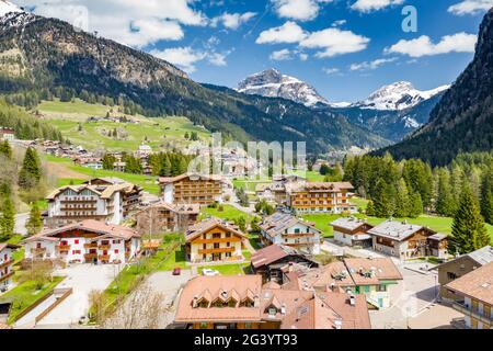 Vista aerea della valle con Chalet, verdi pendii delle montagne d'Italia, Trentino, Fontanazzo, enormi nuvole su una valle, tetto Foto Stock