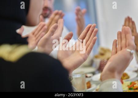 Famiglia musulmana che fa iftar dua per rompere il digiuno durante il Ramadan Foto Stock