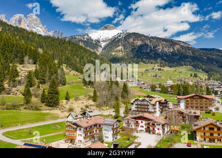 Vista aerea della valle con Chalet, verdi pendii delle montagne d'Italia, Trentino, Fontanazzo, enormi nuvole su una valle, tetto Foto Stock