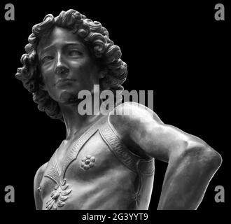 David assassino di Golia antica statua. Storia biblica. Antica scultura di giovane uomo in armatura isolata su sfondo nero Foto Stock