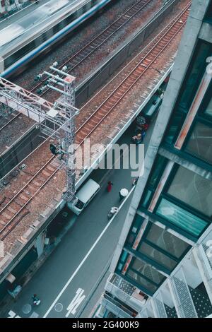 Vista dall'alto in un vicolo accanto a un treno di passaggio a Osaka, Giappone Foto Stock