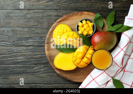Frutta di mango matura e succo su tavola di legno Foto Stock