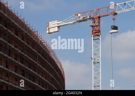 Quartiere in costruzione. Le gru disegnano delle geometrie nel cielo. Foto Stock