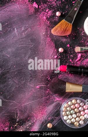 Spazzole per il make-up, perle, rossetto, foto superiore su sfondo scuro Foto Stock