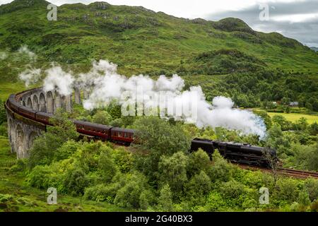 Un treno a vapore d'epoca attraversa il viadotto Glenfinnan a Loch Shiel, Scottish Highlands, Regno Unito. La linea West Highland attraversa Inverness-shire, Scotl Foto Stock