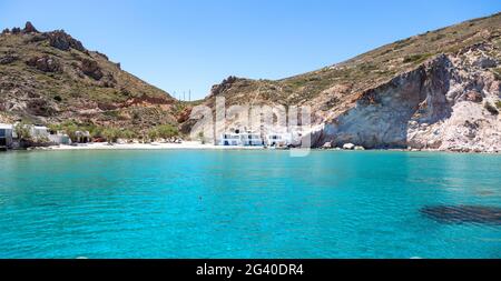 Isola di Milos, Cicladi Grecia. Spiaggia di sabbia, acque turchesi di cristallo di mare. Firoporamos o villaggio di pescatori di Fyropotamos, sfondo blu cielo. Estate Foto Stock