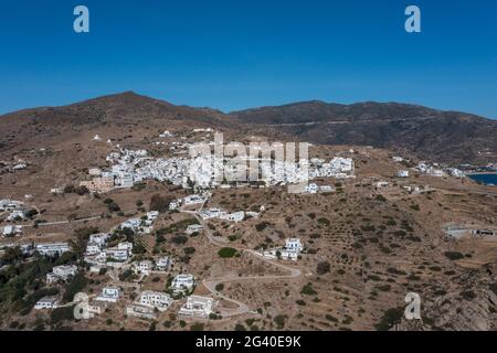 IOS Cicladi isole, Grecia. Vista aerea del drone della città di Chora. Architettura tradizionale delle Cicladi, edifici imbiancati in salita su terreni rocciosi, cielo blu ba Foto Stock