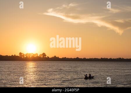 Silhouette di giovane coppia durante l'escursione in kayak dalla nave da crociera sul fiume Mekong al tramonto, vicino Preah Prosop, fiume Mekong, Kandal, Cambogia, Asia Foto Stock