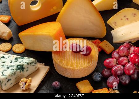 Formaggi e uve su tavola, un assortimento di formaggi vari Foto Stock