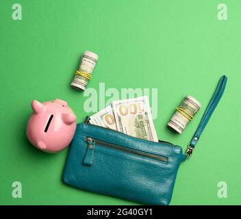 Ceramico rosa piggy banca e carta americano US dollari su sfondo verde Foto Stock
