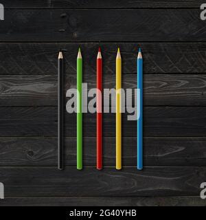 Matite da colorare isolate su sfondo di legno nero Foto Stock