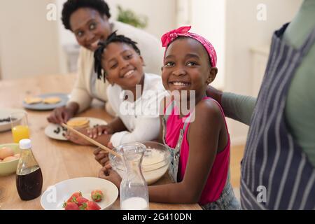 Nonni afro-americani che cucinano con nipote sorridenti e nipote in cucina Foto Stock