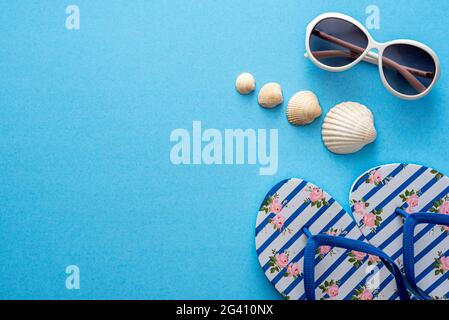 Fotografia a posa piatta di oggetti estivi, occhiali, ciabatte, conchiglie Foto Stock