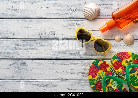 Fotografia a posa piatta di oggetti estivi, occhiali, ciabatte, conchiglie Foto Stock