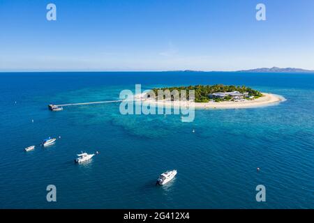 Vista aerea di barche e persone su SUP stand up paddle boards al Malamala Island Beach Club, Mala Mala Island, Mamanuca Group, Isole Fiji, Sud Pacifico Foto Stock