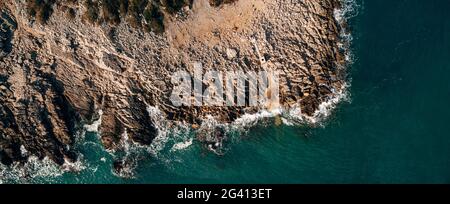 Spettacolare sfondo marino. Costa rocciosa del Mare Adriatico. Onde bianche schiumose battono contro la riva di pietra. Panorama del mare Foto Stock