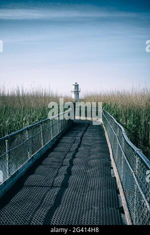 Ponte pedonale che conduce ad un faro. Foto Stock